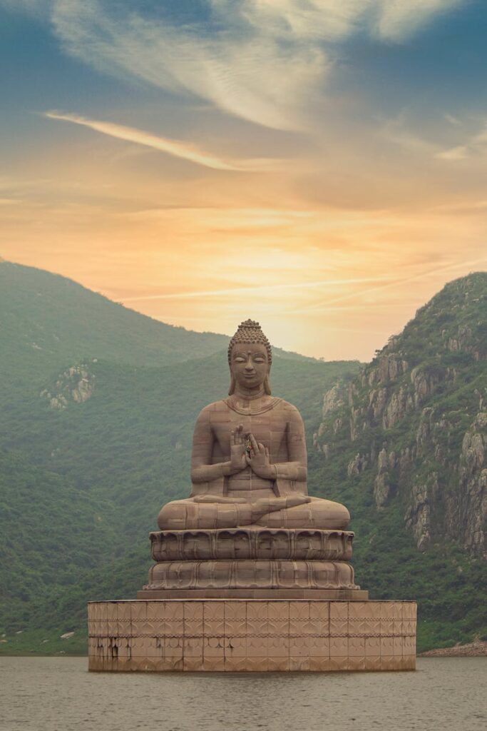 Majestic Buddha statue at Ghora Katora Lake, Rajgir during twilight.